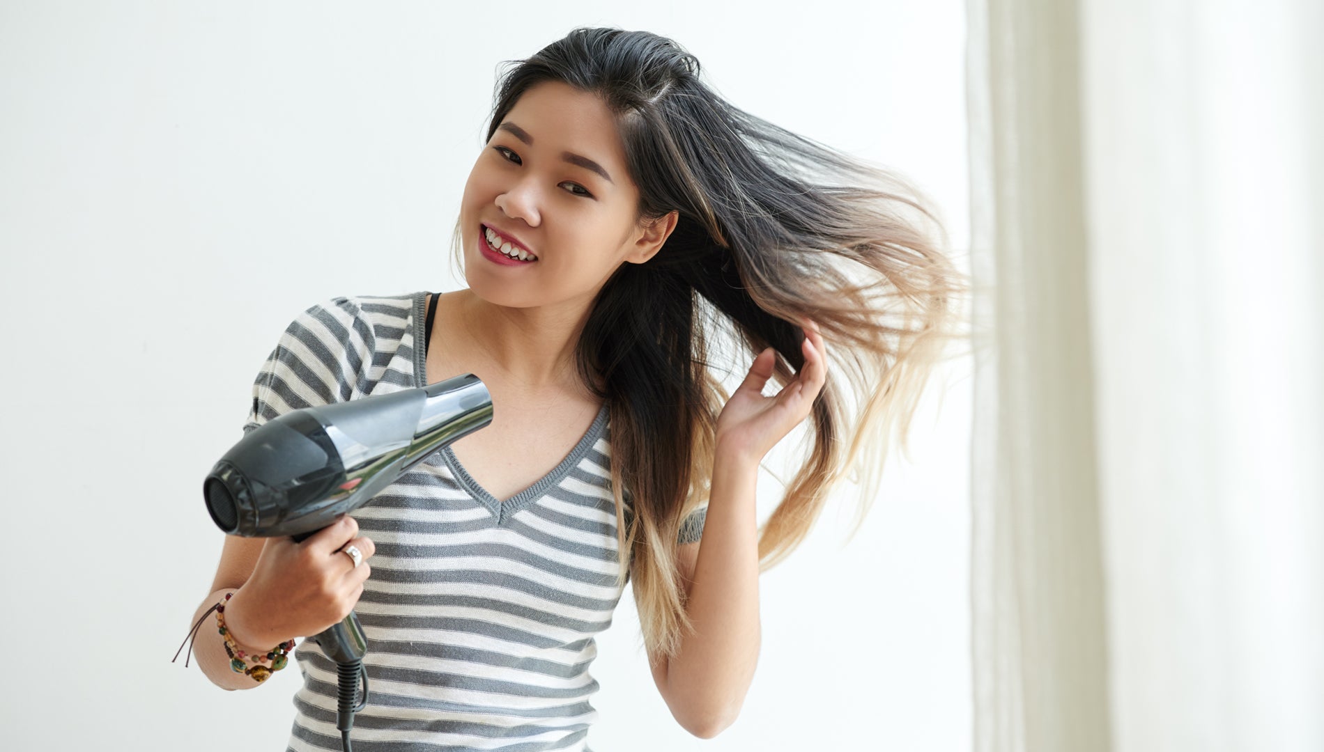 Woman with Hair dryer using on hair