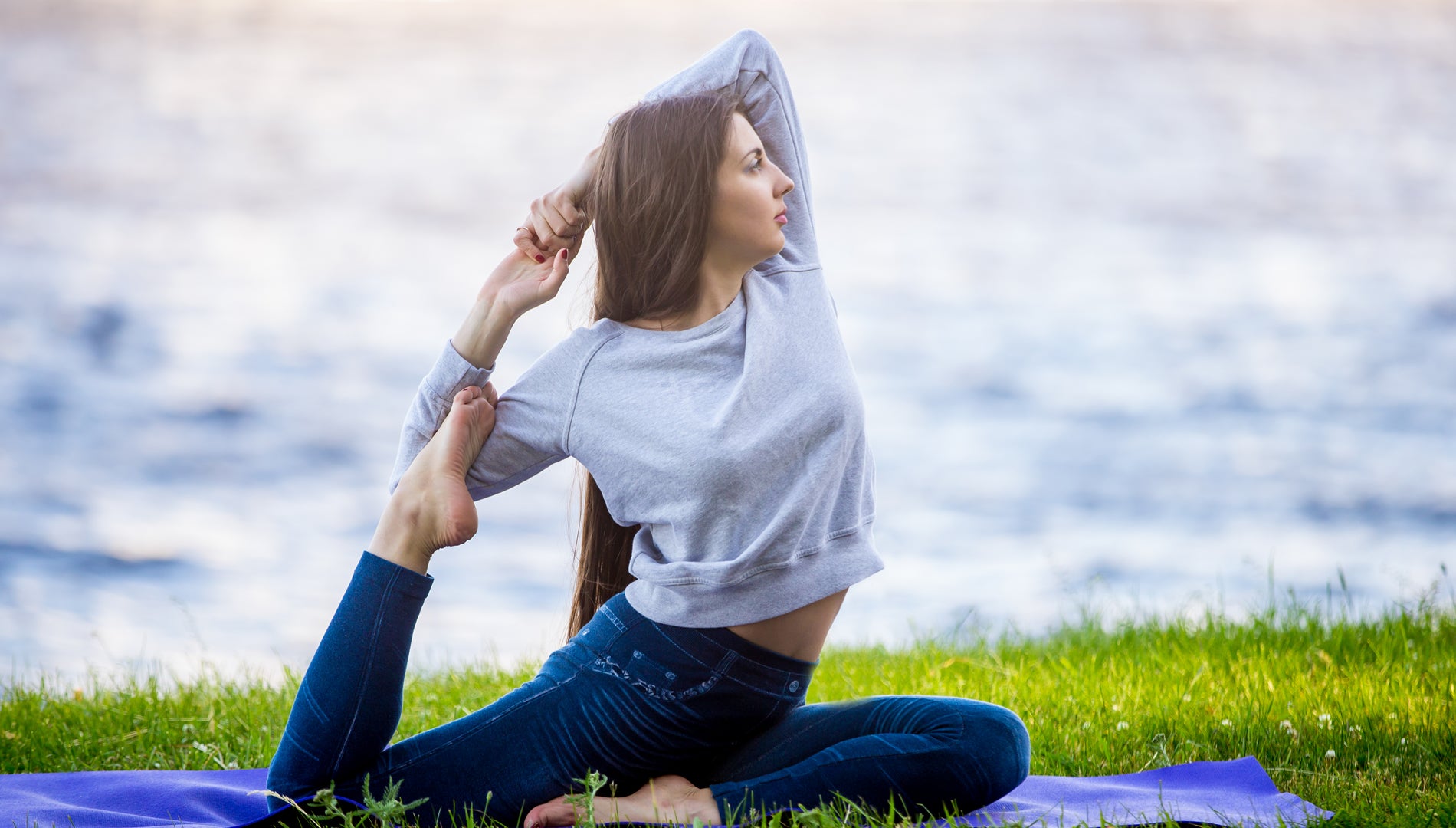beautiful sporty young woman doing yoga on riverbank